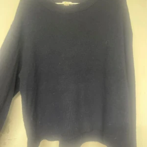 Mörkblå stickad tröja Gina Tricot - Mysig mörkblå stickad tröja från Gina Tricot med rund hals och ribbade muddar vid ärmslut och nederkant. Perfekt för dig som gillar enkel och stilren look. Passar dig som vill ha en klassisk tröja med skön passform.