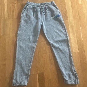 Grå tracksuit från Trapstar M - Säljer en tracksuit från trapstar. Den är i bra skick och är bekvämlig med ett skönt material inuti. Där du har dragkedja där nere på dina byxor som du kan justera. 