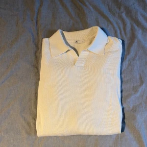 Vit stickad pikétröja från C - Snygg vit stickad pikétröja från Cubus i storlek M. Tröjan har klassisk krage och v-ringad öppning framtill. Perfekt för dig som gillar en clean och stilren look med en twist. Materialet är mjukt och ger en skön känsla hela dagen.