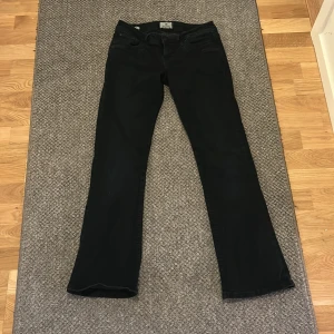 Svarta bootcut jeans LTB Valerie 27/30 - Snygga svarta jeans från LTB, modell Valerie. Bootcut med låg midja och klassisk femficksdesign. Jeansen är tillverkade i bomullsmix och har en stilren look som passar till det mesta. Perfekta för dig som gillar en tidlös och clean stil.