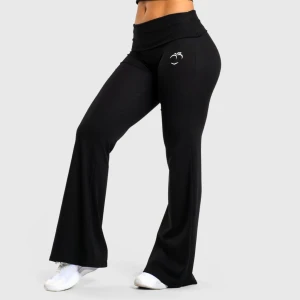 Svarta byxor med utsvängda ben & nedvikbar midja - Svarta mjukisbyxor med nedvikbar midja och vida ben. Byxorna har ett vitt persikotryck framtill vid höften och är tillverkade i mjukt bomullsmaterial som känns skönt mot huden. Perfekta för en chill och avslappnad stil. Passar utmärkt att ha på exempelvis gymmet eller hemma att mysa i.