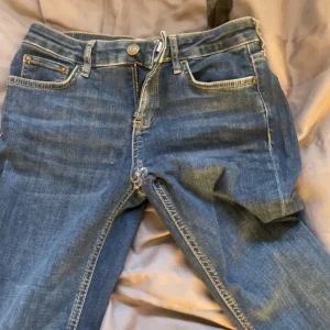 Blå raka jeans med kontrastsömmar - Säljer ett par klassiska blå jeans med raka ben och kontrastsömmar. Jeansen har fem fickor, knapp och dragkedja framtill samt tydliga slitningar vid grenen. Perfekt för dig som gillar en enkel och tidlös look. Har sytt mer Lågmidjade men stygnen syns inte när dom e på!