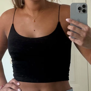 Svart croppad linnetopp - Svart croppad linnetopp från Chiquelle med tunna axelband och enkel, stilren design. 