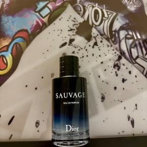Dior Sauvage Eau de Parfum - Dior Sauvage Eau de Parfum är en ikonisk herrdoft i en elegant glasflaska med svart till blå toning och stilren svart kork. Kommer i original svart kartong med vit text. Perfekt för dig som gillar fräscha och maskulina parfymer.
