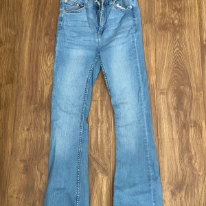 Blå bootcut jeans - Säljer ett par klassiska blå bootcut jeans med normal passform. Jeansen har fyra fickor, dragkedja och knapp framtill.