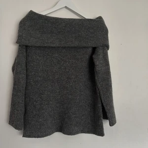 Grå offshoulder stickad tröja - En mysig offshoulder stickad tröja. Säljer pågrund av att har inte någon användning av den längre. Det bara att skriva om ni har några funderingar🌸 🩶