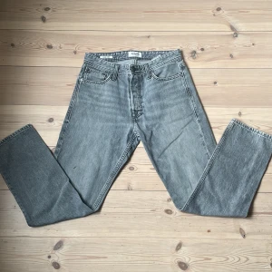 Jeans från jack & jones - Säljer ett par jack & jones jeans i grå tvätt med slitning se bild. Rak passform med fem ficks design. Perfekta för dig som gillar en tidlös och avslappnad stil. Passar både tjejer och killar. Se