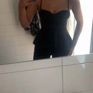 Svart peplum topp med smala axelband - Säljer en svart peplum topp med smala axelband som är ny och aldrig använd