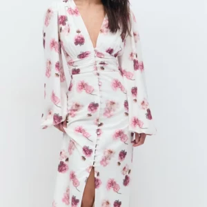 Vit blommig långklänning med v-ringning - Säljer denna supersnygga klänningen från Gina tricot i storlek 34. Helt ny med prislapp på