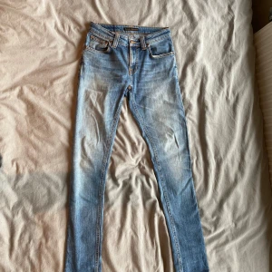 Nudie jeans blåa - Ett par riktigt feta nudie byxor blåa vid storleken W27 L32. Skick på dessa byxor är 10/10 förutom att nudie taggen där bak på byxorna har ”suddats” ut. Hör av dig vid fler frågor el funderingar!