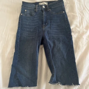 Mörkblåa jeansshorts  - Mörkblå jeansshorts från Gina Tricot, modell MOLLY. Klassisk femficksdesign och hög midja. Perfekta för sommardagar och enkel att matcha med olika toppar.