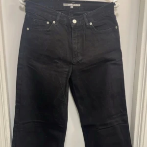 Svarta wide leg jeans från Junkyard - Säljer ett par svarta wide leg jeans från Junkyard. Byxorna har klassisk femficksdesign, hög midja och raka, vida ben. Perfekta för dig som gillar en avslappnad och trendig stil.