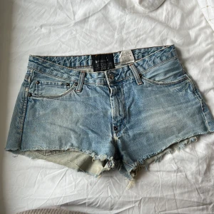 Ljusblå jeansshorts från Acne - Säljer ett par klassiska ljusblå jeansshorts från Acne Jeans i perfekt färg. Det står ingen storlek men midjemåttet är: 39 cm och måttet rakt ner vid gylfen är: 27 cm. De är lite slita vilket jag tycker gör de snygga. 