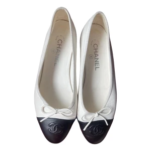 Chanel ballerinaskor - Klassiska ballerinaskor från Chanel i vitt tyg med svart tå i skinn. Använda men i fint skick. Storlek 37,5 (passar mig som har 37). 🖤
