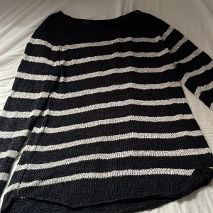 Svart och vit randig stickad tröja - Säljer en svart och vit randig stickad tröja med lång ärm. Tröjan har en avslappnad passform och är perfekt för kyligare dagar. Mjukt material och klassiskt mönster som passar till mycket.