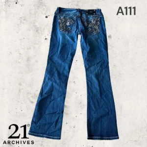 Blå bootcut miss me jeans  - Säljer ett par blå bootcut jeans med snygga broderade detaljer på bakfickorna. Jeansen har klassisk femficksdesign och kontrastsömmar. Perfekta för dig som gillar en lite vidare passform nertill och vill sticka ut med detaljer. Inga defekter nästan aldrig använd