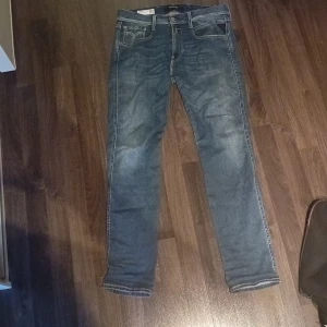 Blå Replay Anbass jeans herr W31 - Säljer ett par klassiska blå Replay Anbass jeans i herrstorlek W31. Jeansen har normal passform, raka ben och fem fickor. Snygg tvätt med lätt slitning och dragkedja i gylfen. Perfekta för en stilren vardagslook. Model slimfit.Längd 32