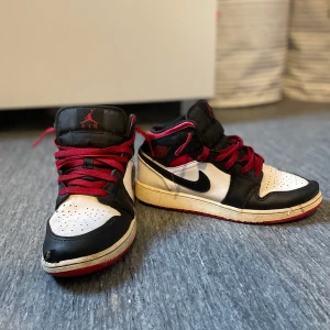 Nike Air Jordan 1 med röd, svart och vit färg - Jordan 1 i storlek 39 lite trasiga längst fram. Snygga skor och enkla att matcha