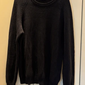 Svart ribbad tröja från Zara Man - Säljer en svart ribbstickad tröja från Zara Man i 100% bomull. Tröjan har lång ärm och rund halsringning. Passar till många olika outfits och är riktigt skön att bära. Aldrig använd, nypris ca 500
