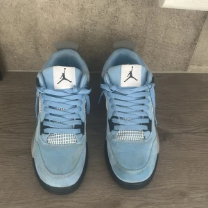 Nike Air Jordans i ljusblå mocka - Säljer ett par Nike Air Jordans i ljusblå mocka med vita och svarta detaljer. Skorna har snörning, vit mesh på sidorna och klassisk Jumpman-logga på plösen och hälen. Snygg kontrast mellan den ljusblå ovandelen och den svarta sulan.