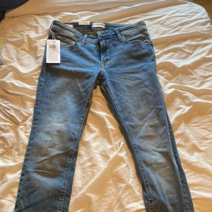 Blå skinny jeans från Jack & Jones - Ett par blåa skinny jeans från Jack & Jones, har aldrig använts och lapparna sitter kvar, också fina fickor bakpå. Jag säljer dom åt min pappa som aldrig använt dom. Vet onte storleken men ser ut att passa mellan S-M, 39cm i midja tvärsöver