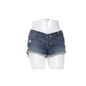 Lågmidjade jeansshorts från Hollister - Snygga mörkblå jeansshorts från Hollister med slitna detaljer och råa kanter. Säljer då jag har ett par liknande💕