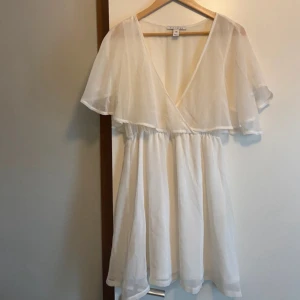 Vit klänning/omlottklänning - Säljer en vit kort tunn klänning i så fint skick. Normal i storleken, säljer billigt!
