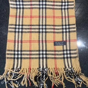 Beige Burberry halsduk. Authentic - En mörkblå halsduk med vita och röda linjer. Denna vara köpte jag för två år sedan när en hemsidan skulle stänga ned så allting var på rabatt. Så jag har några burberry halsdukar till salu som du kan köpa och sälja igen sen och gå plus! Riktigt bra! Snälla köp vill bli av med den. Den är riktigt så kom inte och fråga. 