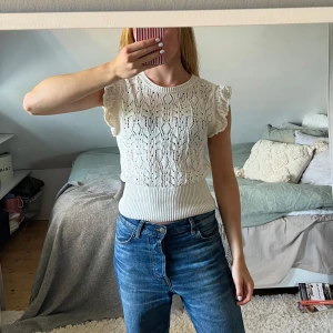 Vit stickad blus med volangärm - Supersöt vit stickad blus med volangärmar. Storlek S, använd fåtal gånger, jättefint skick. Lindex