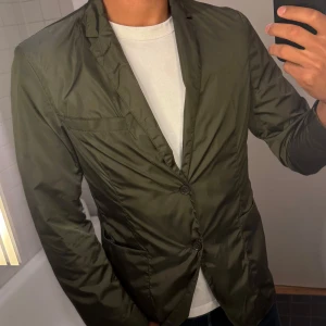 Blazer/Kavaj/Jacka Tiger of Sweden - Säljer en riktigt fräsch blazer jacka från Tiger of Sweden , i en grön färg som skiner lite i solljus, därav lite svår att fota. Den är näst intill oanvänd! Storlek: M (48)