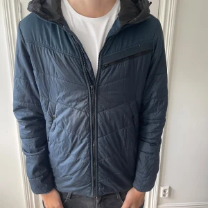 Blå quiltad pufferjacka G-Star Raw - Säljer en blå quiltad pufferjacka från G-Star Raw i storlek M. Jackan har huva, dragkedja framtill och flera praktiska fickor med dragkedja. Snyggt mönstrad med diskreta sömmar och perfekt för kyligare dagar.
