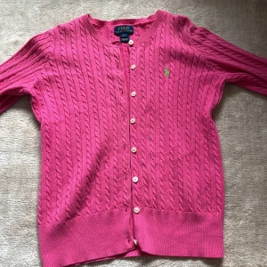 Rosa stickad kofta från ralph lauren - Säljer denna rosa koftan från ralph lauren barn som är använd några gånger men i bra skick endå! Säljer pågrund av att jag inte har använt den nästan alls! Pris kan diskuteras och hör av er om ni har frågor! Nypris cirka 1000 kr  