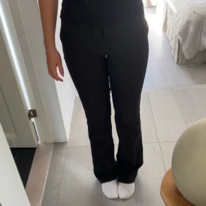 Svarta kostymbyxor med bootcut - Snygga svarta kostymbyxor med bootcut-snitt från bikbok st 34, säljer pågrund av att de tyvärr blivit lite små💕 använd fåtal gånger, bara att fråga om ni vill ha mer bilder eller har någon fråga🥰