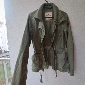 Så fin olivgrön jacka från Hollister - Snygg olivgrön jacka från Hollister med en dragkedja framtill. Jackan har en avslappnad passform och är perfekt för lager-på-lager. Tillverkad i bomull och har långa ärmar. En jacka som inte säljs längre och funkar perfekt nu inför hösten🥰