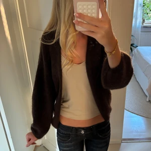 Brun kofta i mohairblandning - Mysig brun cardigan jacka från Lindex med nypris 899 kr. Tillverkad i en mix av polyester, mohair och ull. Den är endast använd ett fåtal gånger och även därför jag säljer den.