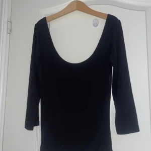 Svart topp med djup rygg - En svart, tight topp från Gina Tricot med djup urringning i ryggen och trekvartsärm. Enkel och stilren design som passar perfekt till jeans eller kjol. Mjuk och stretchig bomullskänsla för en bekväm passform. Säljer för den är lite för stor, endast använd 1 gång. Storlek xs/S. Köpte på rea när den kostade 100. Varan säljs på flera plattformar💕