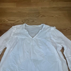 Blus från Gina Tricot - Vit blus med mönstring uti ärmarna. Den är från barnavdelningen i storlek 158/164. Säljes pga rensning av garderob. Tvättas och stryks innan den skickas. Skriv vid funderingar 💓