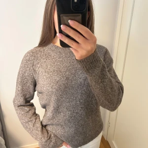 Brun stickad tröja - Mysig brun stickad tröja med rund halsringning och långa ärmar. Tröjan har en enkel och stilren look med ribbade muddar vid ärmslut och nederkant. Använd 1 gång💕