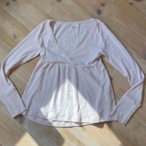 Ljusrosa babydoll topp från Hollister - Säljer denna super söta rosa hollister topp i strl xs! Kommer inte till användning, bara använt 2 ggr. Säljs ej längre 