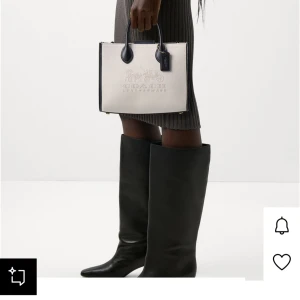 Coach beige handväska med svarta detaljer - Snygg handväska från Coach i beige canvas med svarta skinnhandtag och detaljer. Nypris 4800