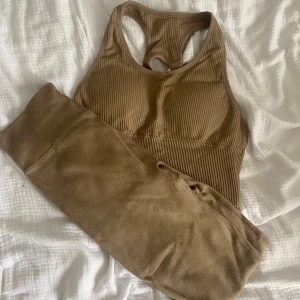 Träningset  - Säljer en ribbad beige sport-bh i storlek XS. Toppen har sportig racerback med justerbara band. Byxorna är matchande till toppen och i storlek S. Båda för 100 eller en för 50! Köpt på ullared