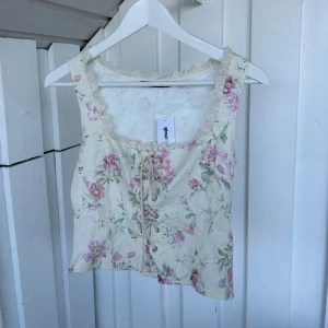 Blommig korsettopp från Gina Tricot - slut såld korsett från gina! helt oanvänd då den är för stor🩷🤍💚