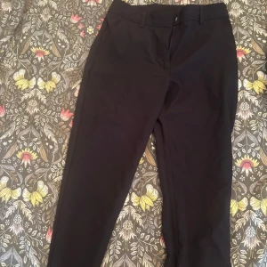 Svarta kostymbyxor från Primark - Svarta kostymbyxor från Primark i klassisk rak modell. Byxorna har hällor för bälte och diskreta sidfickor. Perfekta för en clean och stilren look, passar till allt från skjorta till hoodie.