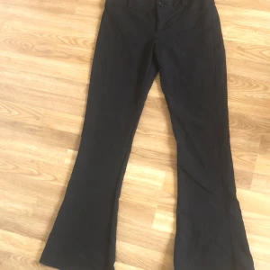 Svarta bootcut byxor - Svarta kostymbyxor med bootcut passform och normal midja. Byxorna har fickor bak och stängs med knappar och dragkedja. Köpt för ett år sen, är för små nu tyvärr. Nypris = 500kr 💕