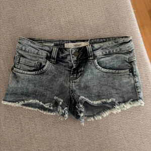 Blåa lågmidjade jeansshorts från Subdued - Snygga blåa jeansshorts från Subdued med slitna kanter och fransar. Är i lågmidjad modell. Använd fåtal gånger.