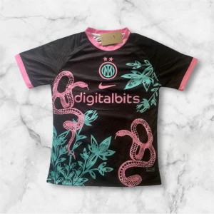 Inter Milan fotbollströja med ormmotiv - Säljer en svart Inter Milan fotbollströja från Nike med rosa detaljer och turkosa ormar och växter på framsidan. Tröjan har korta ärmar och klubbmärke samt sponsortryck på bröstet. Perfekt för dig som vill sticka ut på planen!