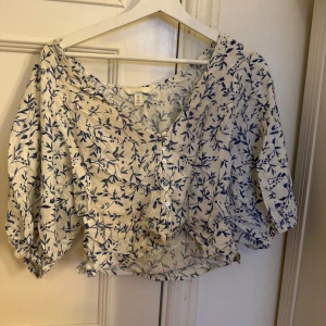 Blommig HM blus  - Säljer en luftig blus i vit linneblandning med blått blommönster. Den säljs inte längre och är i väldigt fint skick!❤️