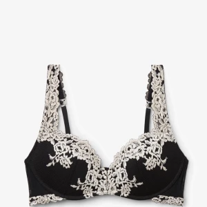 Svart spets-bh med broderade detaljer - Snygg svart bh med vackra broderade spetsdetaljer i vitt längs kupor och axelband. Ger en lyxig känsla och passar perfekt under både vardags- och festkläder. Justerbara axelband för bästa passform.