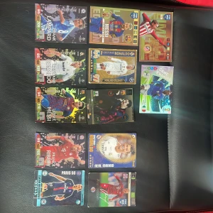 Samling av fotbollskort med kända spelare - Säljer en samling fotbollskort med stjärnor som Messi, Ronaldo, Ribery och fler. Korten har färgglada designer, holografiska effekter och klubbmärken. Perfekt för samlare eller fotbollsfans som vill ha unika kort från olika lag och turneringar.