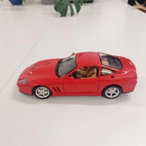 Röd modellbil Ferrari - Säljer en detaljerad röd modellbil av Ferrari i plast och metall. Bilen har öppningsbara dörrar och inredning i beige. Perfekt för samlare eller som dekoration.